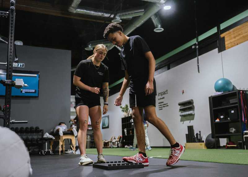 Coach guiding a youth athlete through agility and strength training in San Diego
